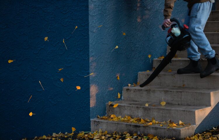 階段の落ち葉を掃除する男
